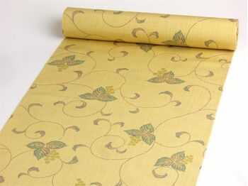A tsumugi kimono woven in Tango, featuring an arabesque pattern in yellow orange
