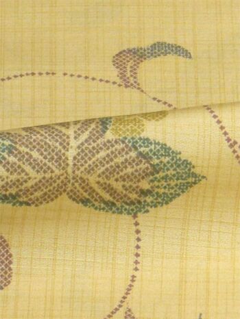 A tsumugi kimono woven in Tango, featuring an arabesque pattern in yellow orange
