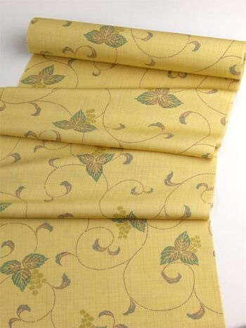 A tsumugi kimono woven in Tango, featuring an arabesque pattern in yellow orange